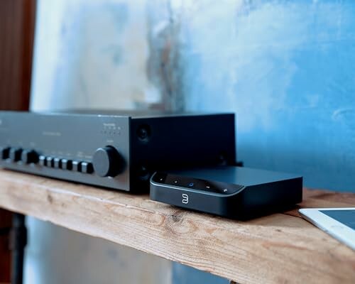 Audio equipment and amplifier on a wooden shelf.